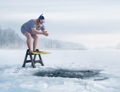 man-dressed-for-scuba-preparing-to-jump-in-frozen-lake