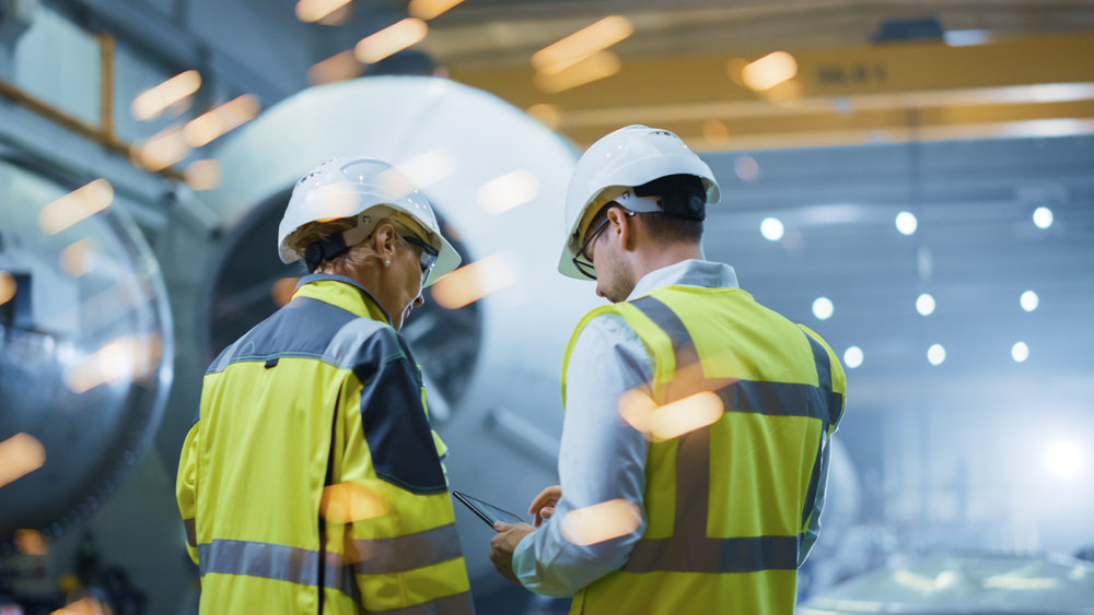 Two engineers reviewing checklist in warehouse