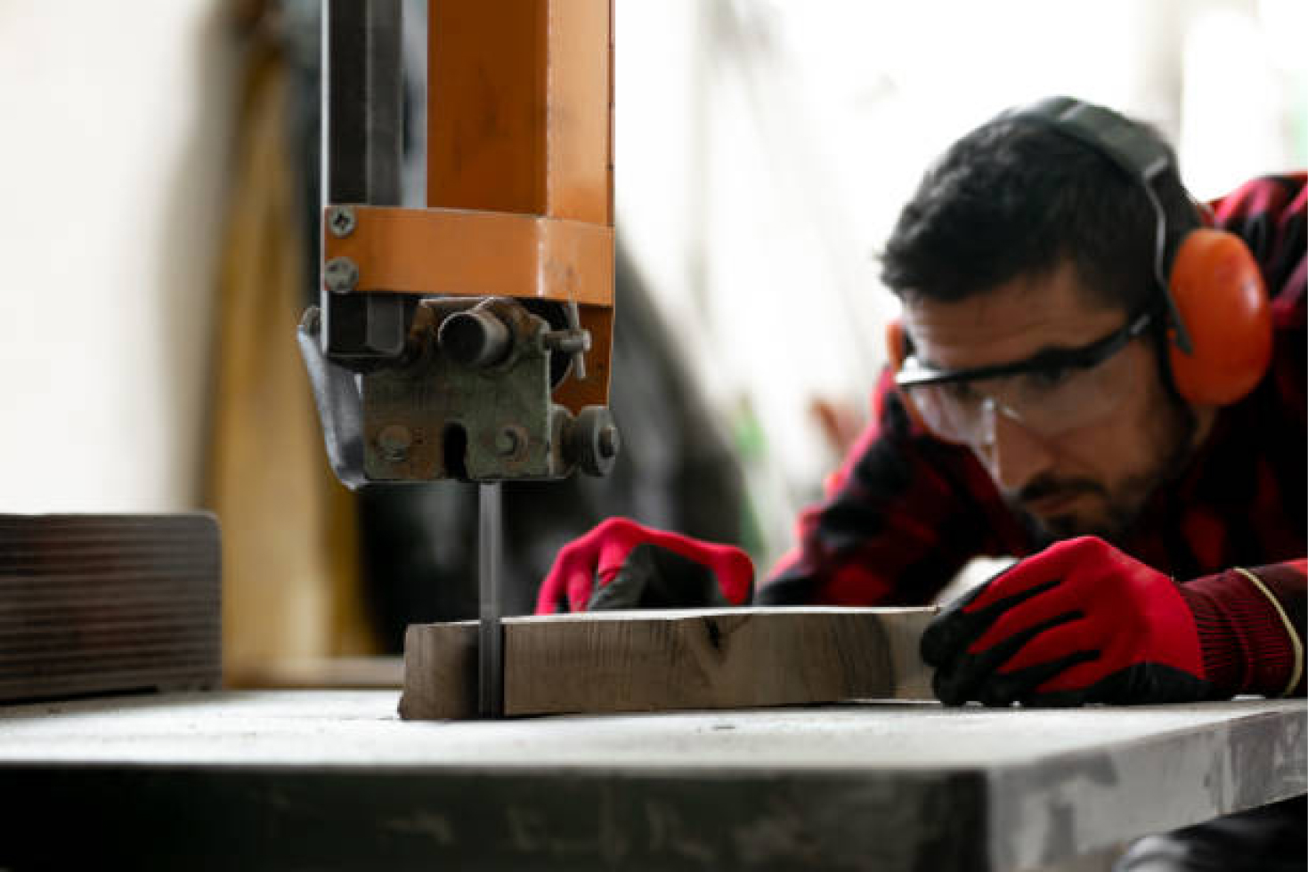 man-wearing-protective-gear-while-sawing-wood