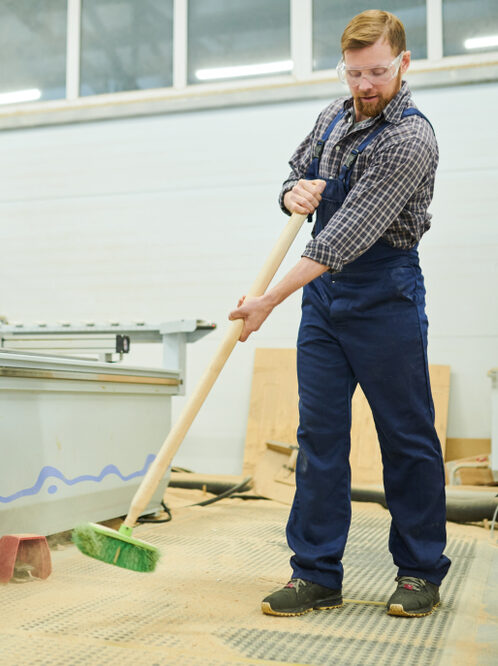 Man sweeping floor in factory