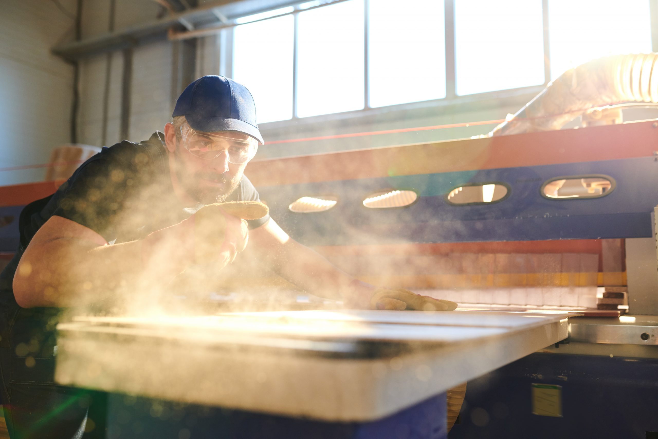 man-using-saw-in-mill-generates-wood-dust